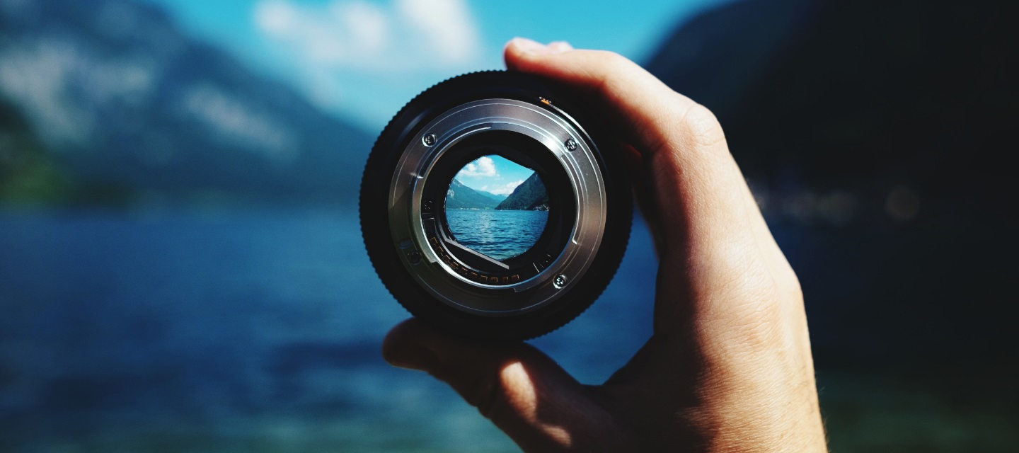 View through a scope at a lake and mountains