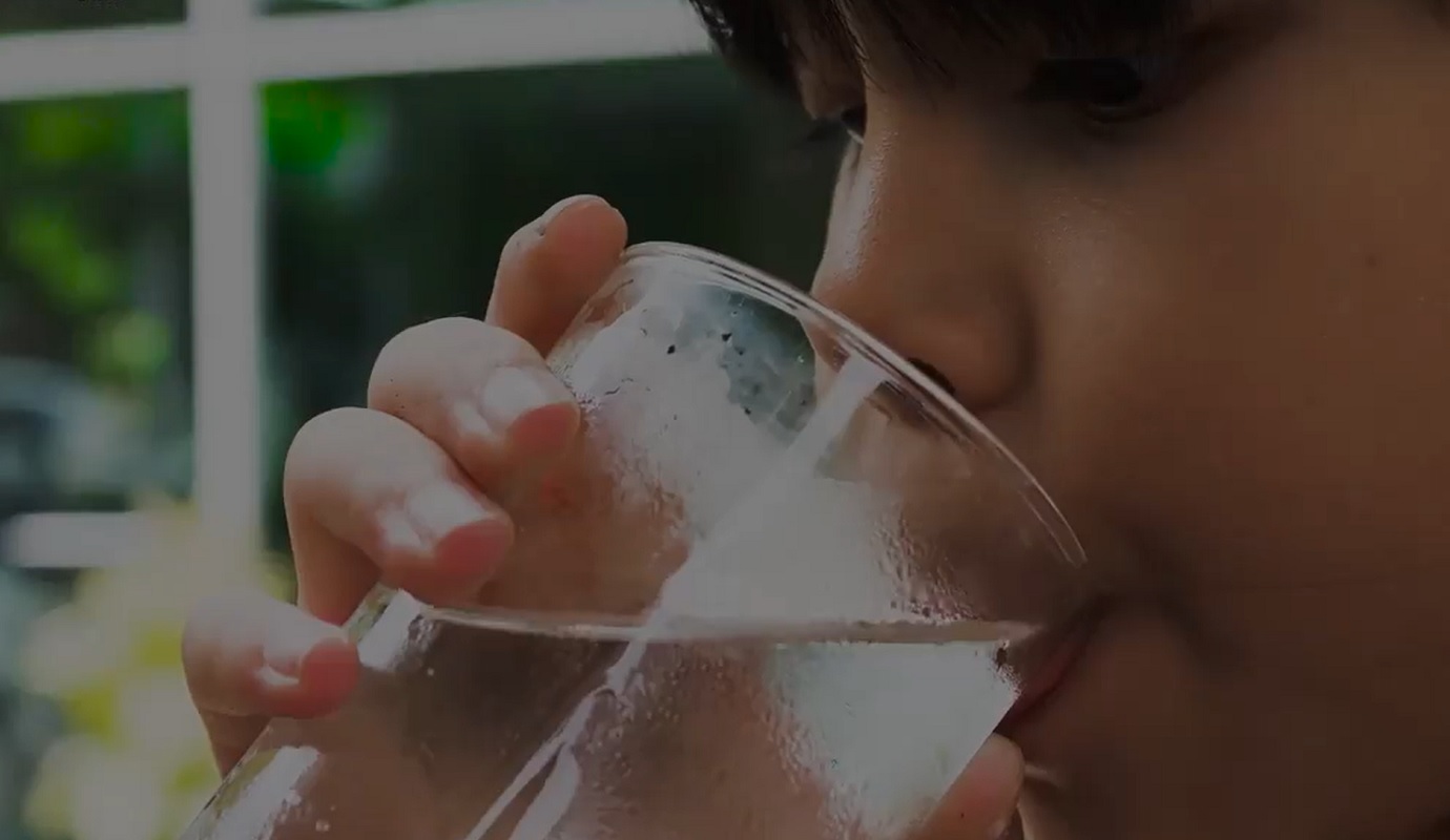 A girl drinking clean water from a glass